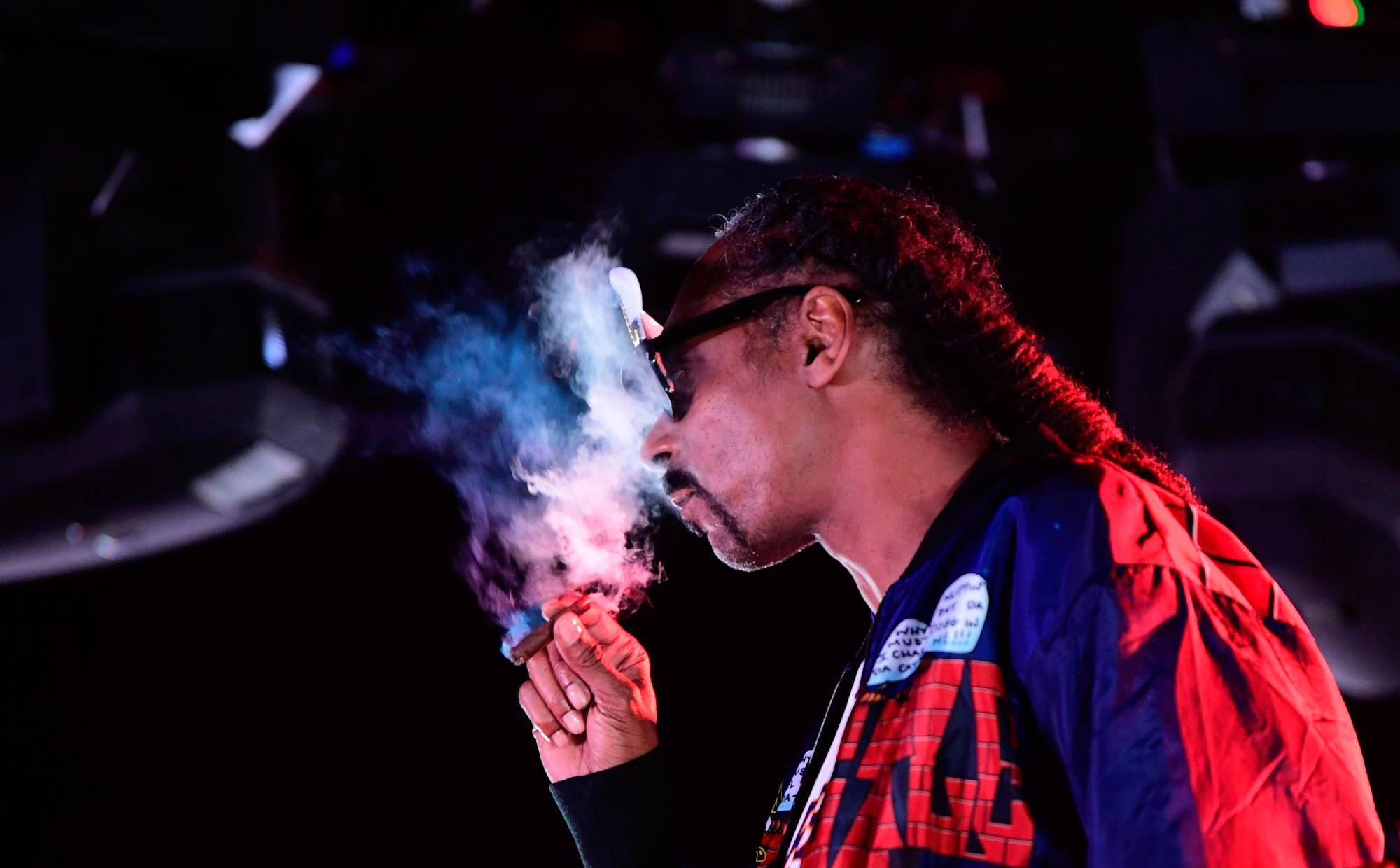 Snoop Dogg smokes while performing on stage during a 