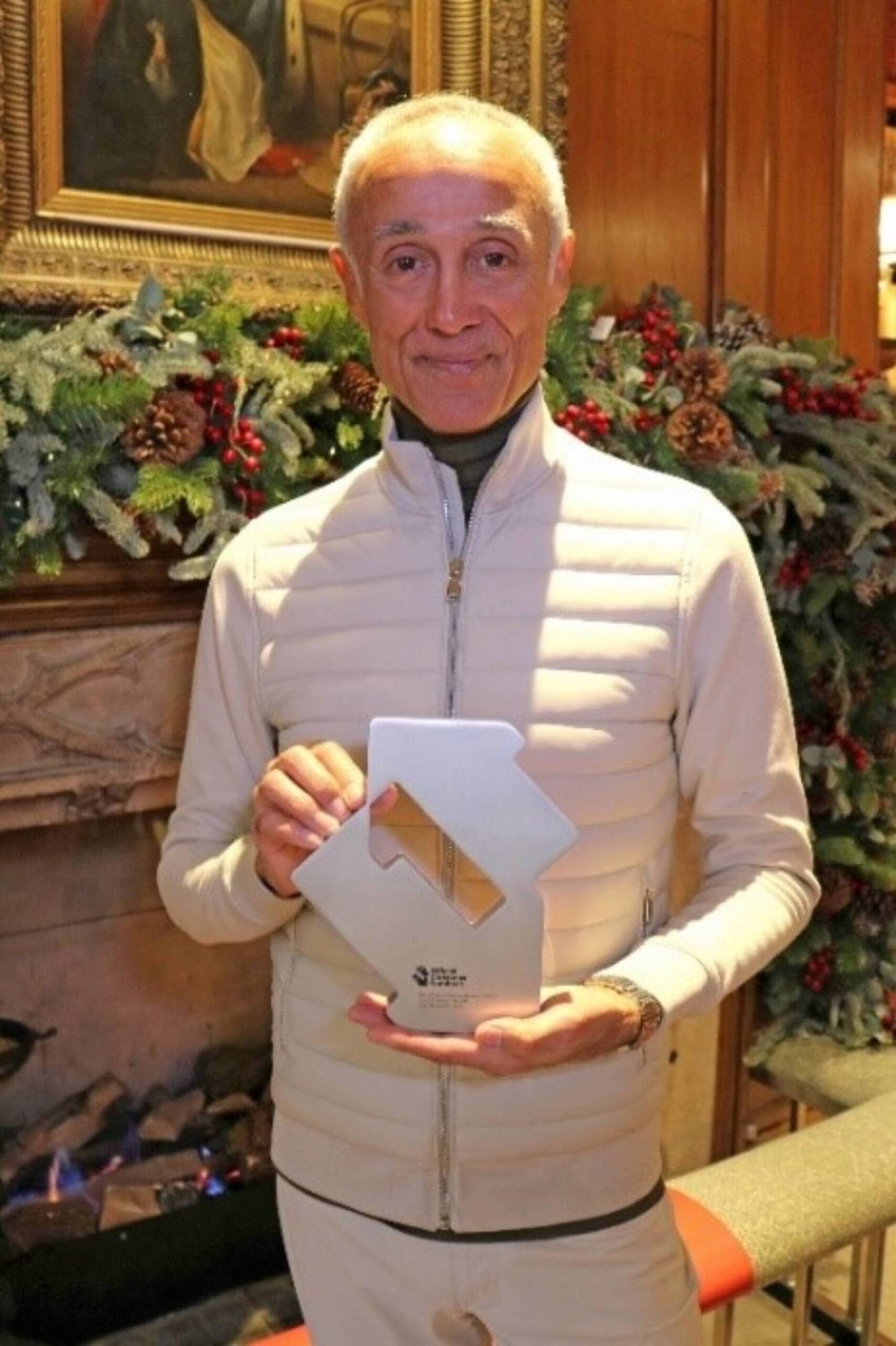 WHAM!’s Andrew Ridgeley celebrates Last Christmas claiming 2023’s Official Christmas Number 1 single with his Official Number 1 Award from Official Charts. Credit: Official Charts