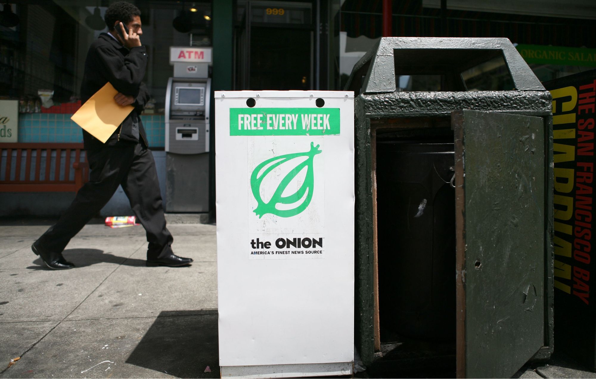 A pedestrian walks by an Onion news rack